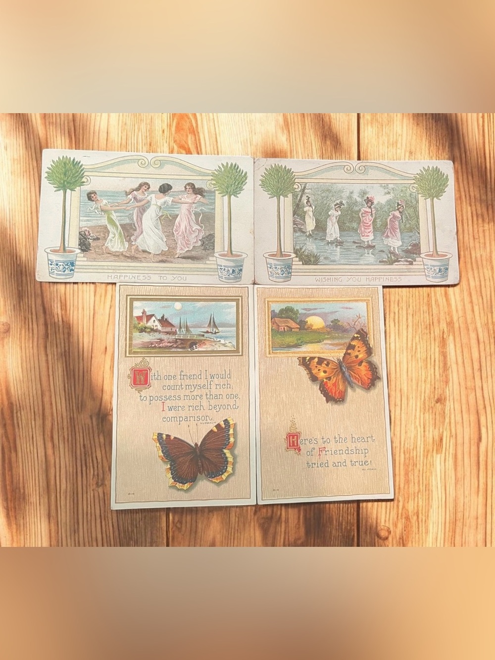 A set of four antique postcards with friendship and happiness sentiments.